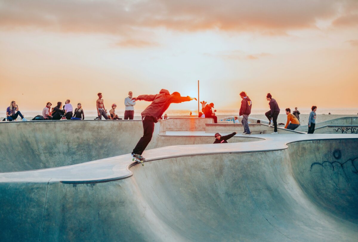 Skaters and onlookers at Venice State Park at sunset in Venice Beach, Los Angeles, California