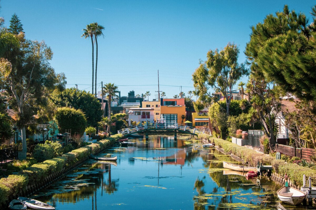 View down a cottage-lined canal at Venice Canal Historic District, a tourist attraction of Venice Beach, Los Angeles, California