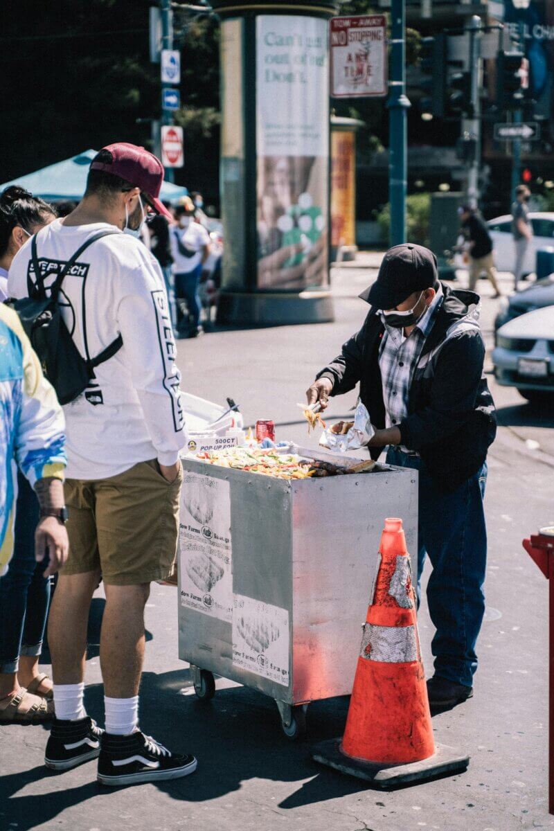 A San Francisco street vendor sells hot dogs to a customer